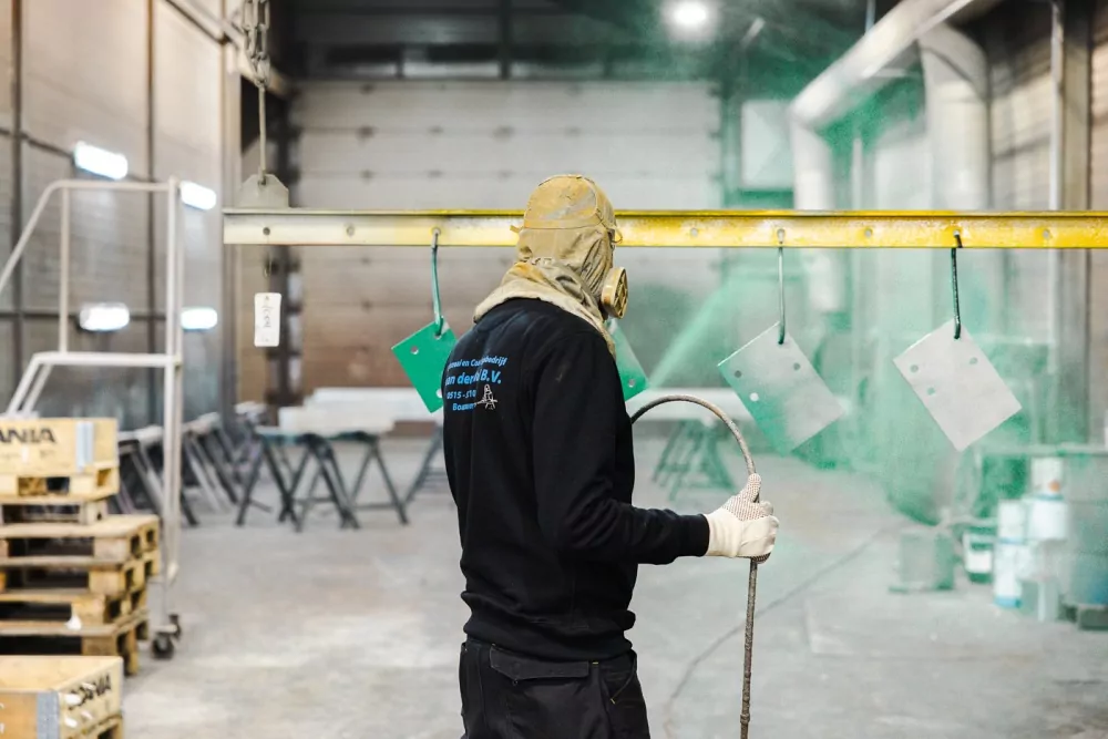 Medewerker van T. van der Wal B.V. aan het werk in de coatinghal
