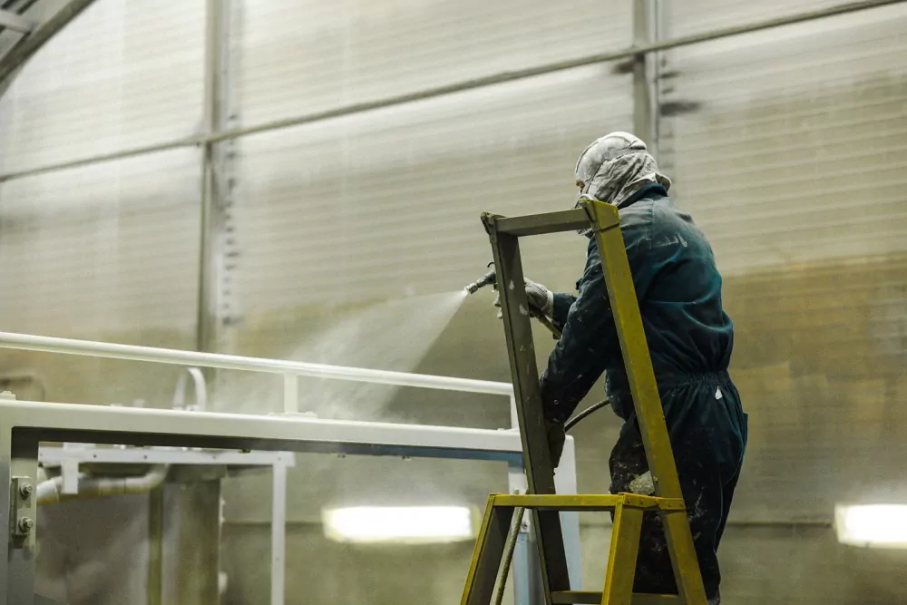 Handmatig coaten van een metalen constructie in de werkplaats