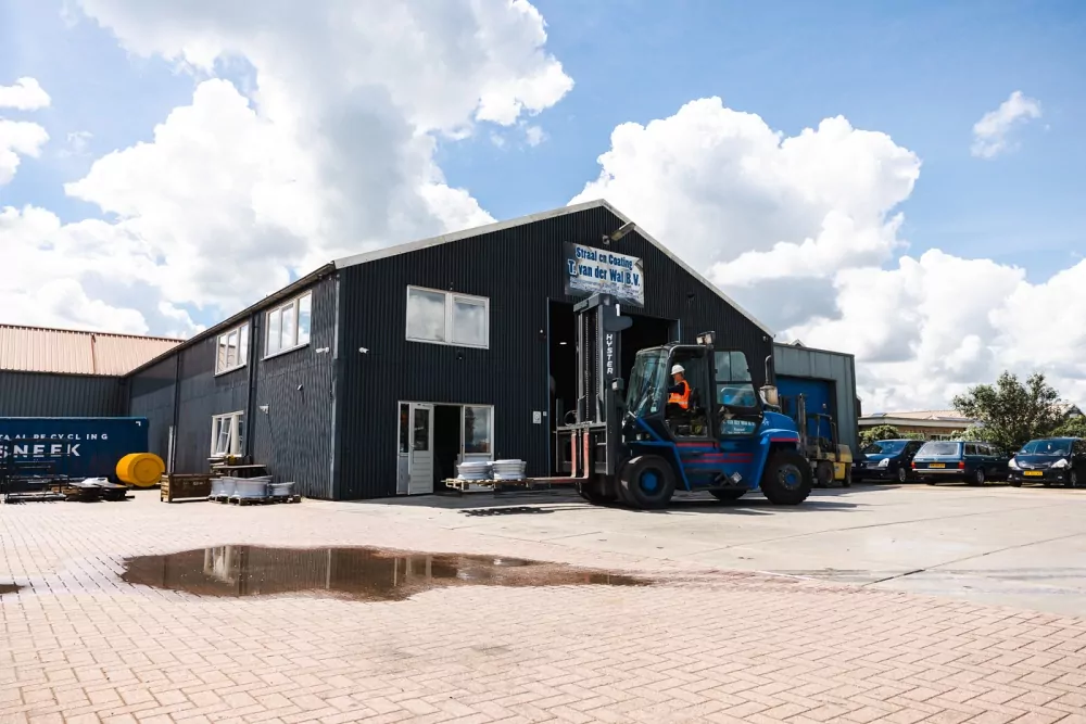 Buitenzijde van het bedrijfspand van T. van der Wal B.V. met hoogwerker