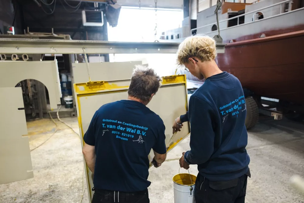 Stagiair krijgt begeleiding van een ervaren medewerker in de werkplaats